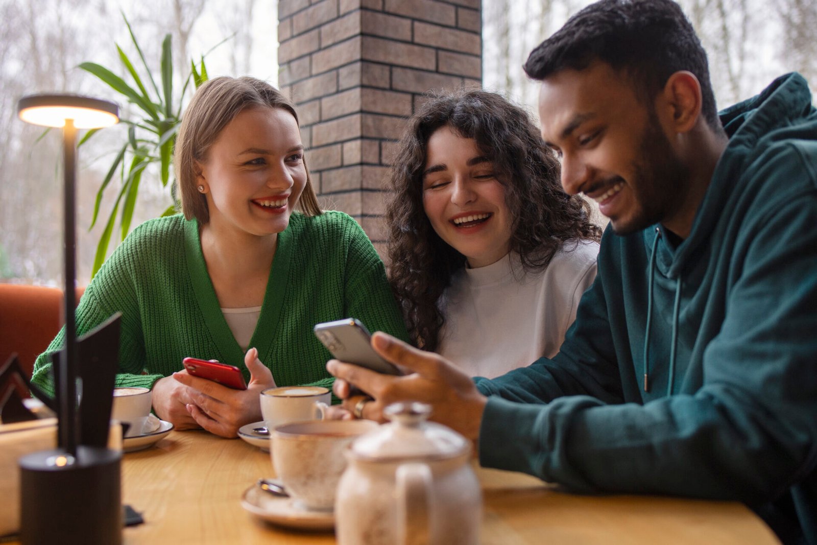 medium-shot-smiley-friends-with-smartphone.jpg