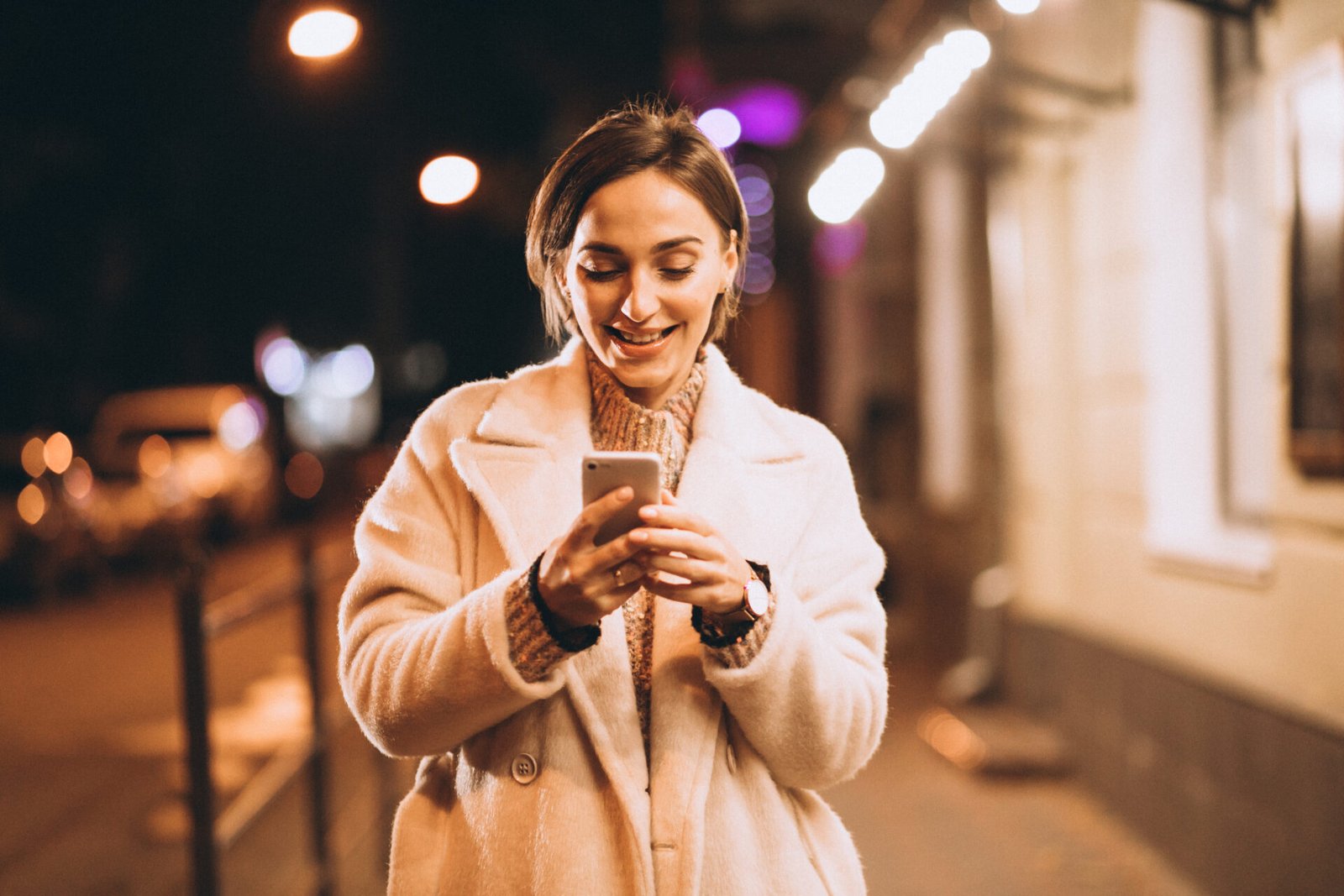 young-woman-using-phone-outside-night-street.jpg